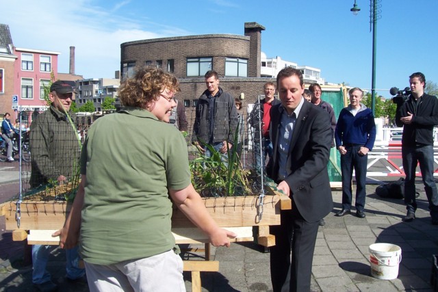 De tweede watertuin wordt door o.a. wethouder Frank de Wit (rechts) naar de nieuwe locatie gedragen